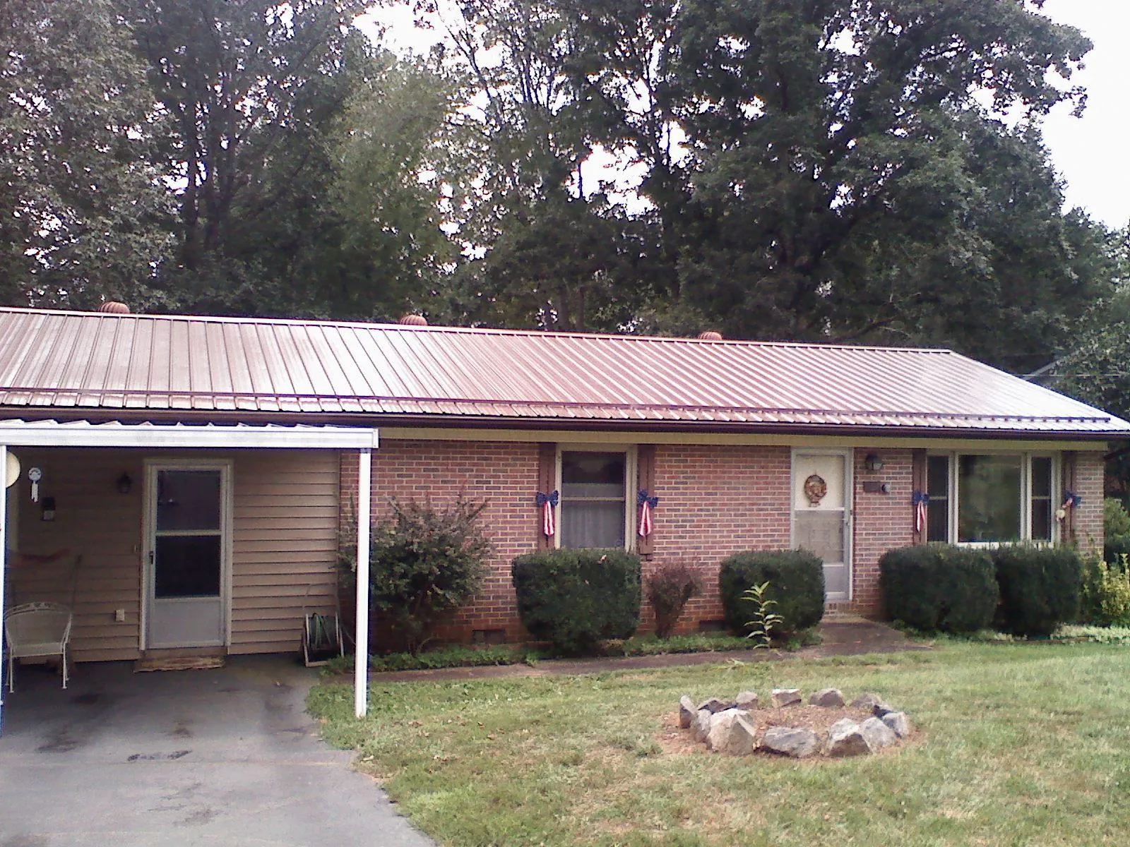 Bronze metal roof and carport on a brick ranch home — Roof Repair work by our crew in Lenox